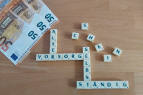 Geldscheine und Würfel mit Buchstaben